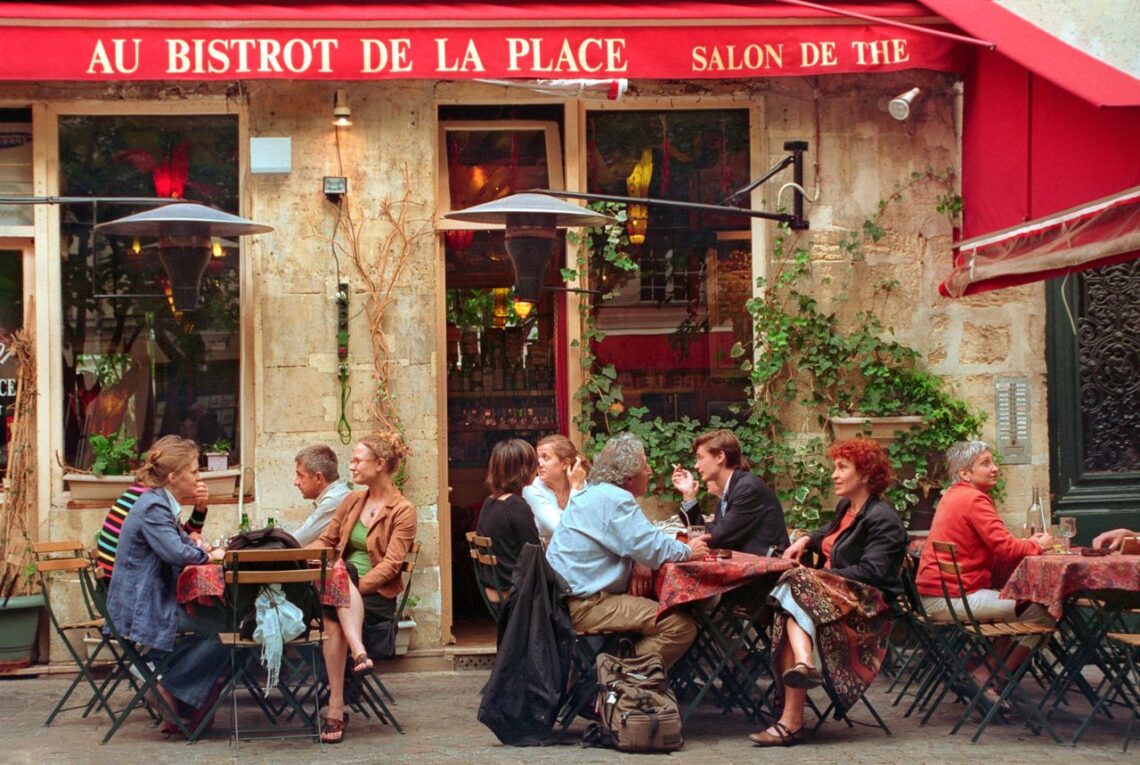 Outdoor seating at a bustling Parisian bistro, capturing lively conversation and vibrant atmosphere.